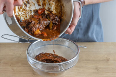 Demi Glace durch einen Sieb auffangen