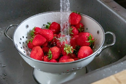 Erdbeeren unter Wasserhahn waschen