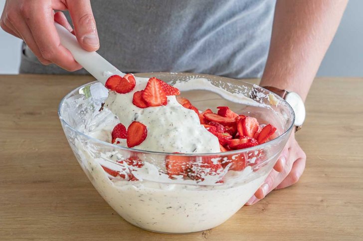Erdbeeren unter die Creme heben