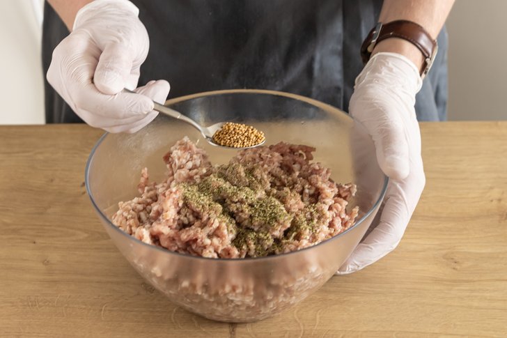 Gewürze unter das Fleisch mischen