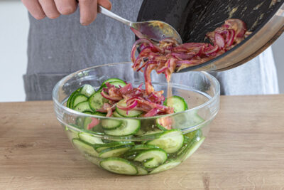 Zwiebel in den Gurkensalat geben