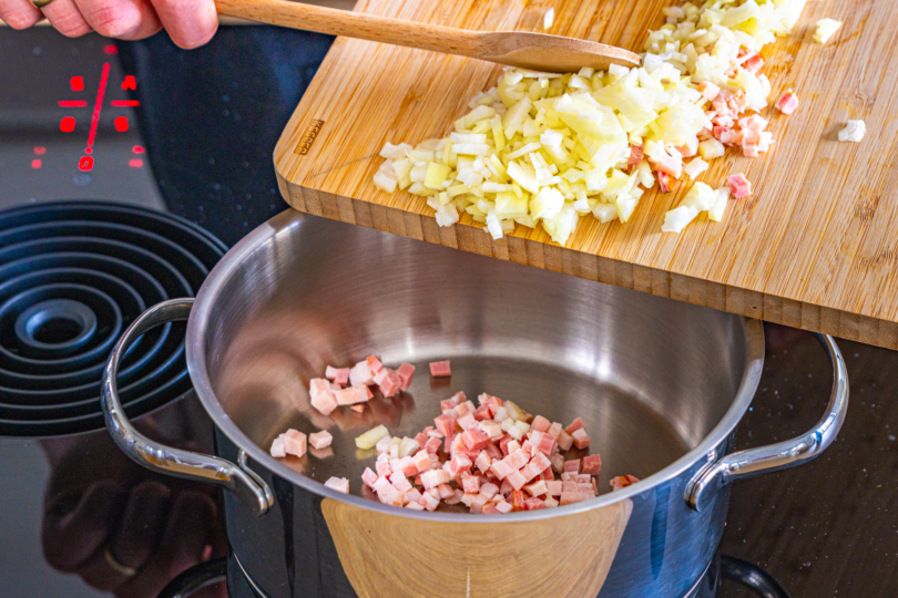 Zwiebeln und Speck in den Topf geben für traditionelles Sauerkraut