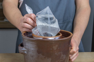 Gärgewicht auf Sauerkraut legen