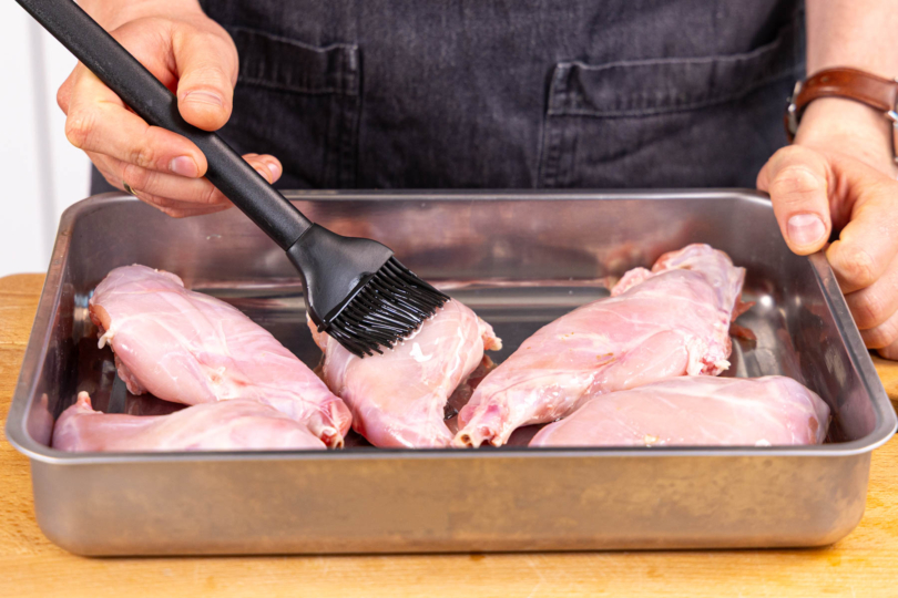 Kaninchenkeulen mit Öl einstreichen und würzen