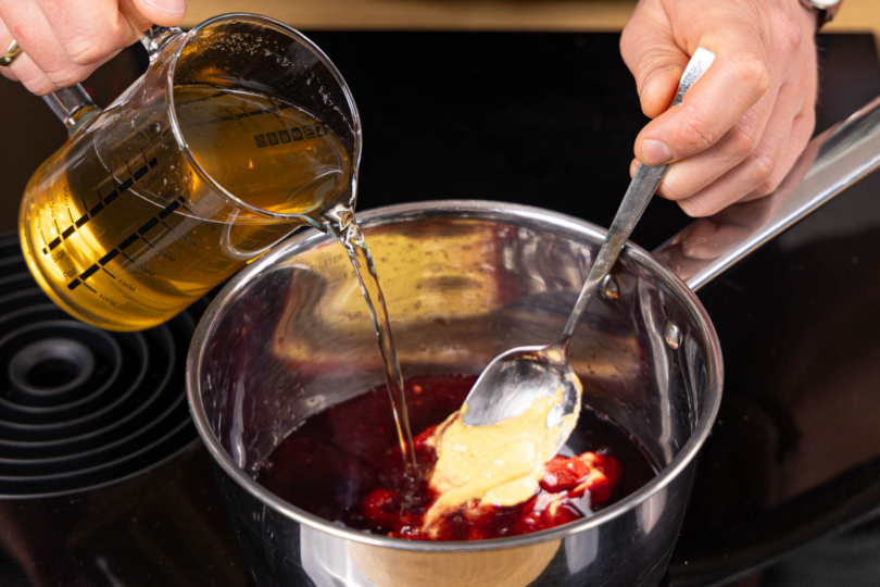 Gemüsebrühe, Rotwein, Tomatenmark und Senf in einem Topf aufkochen