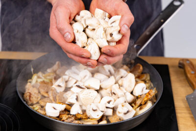 geschnittene Champignons und Fleisch in die PFanne geben