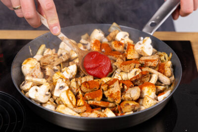 Paprikapulver und Tomatenmark ebenfalls anschwitzen