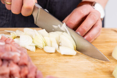 Zwiebel und Knoblauch schälen und in Streifen schneiden