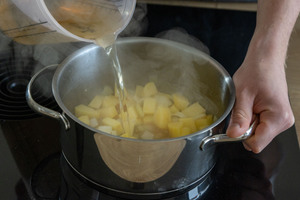 Gemüsebrühe zu Kartoffeln gießen