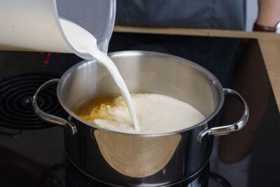 Milch zur Gemüsebrühe gießen
