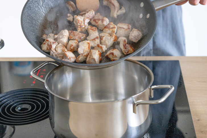 Gulasch in den Topf geben