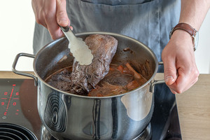 Weichen Hirschbraten aus dem Topf nehmen