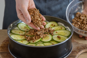 Brotkrümels auf Gurkenscheiben geben