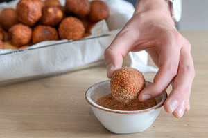 Quarkbällchen in Zucker und Zimt wälzen
