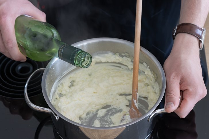Weißwein hinzugeben
