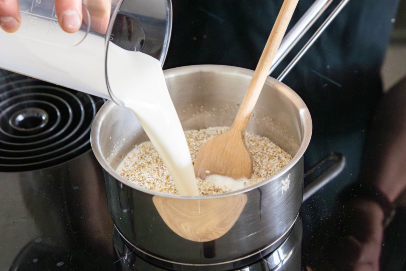 Milch zum Buchweizen gießen