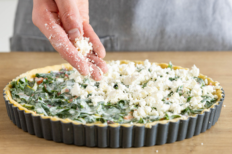 Mangold-Quiche mit Feta bestreuen