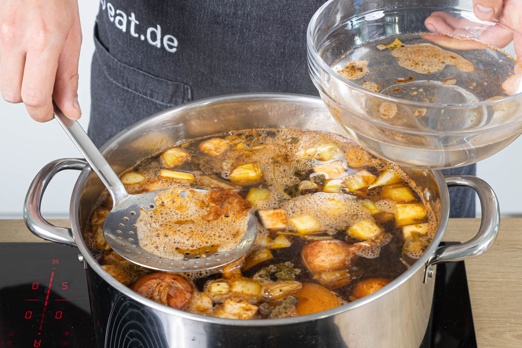 Schaum von der Brühe abschöpfen