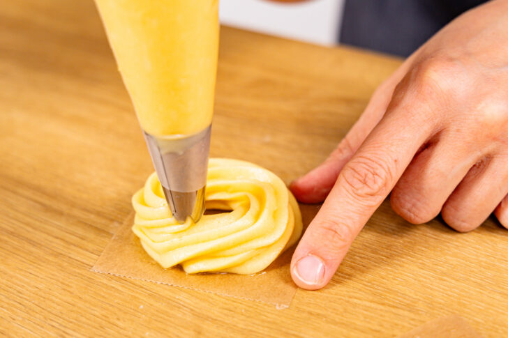 Brandteig als Spritzring aufs Backpapier spritzen