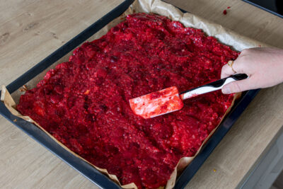 Himbeerschicht auf dem Kuchenteig verteilen