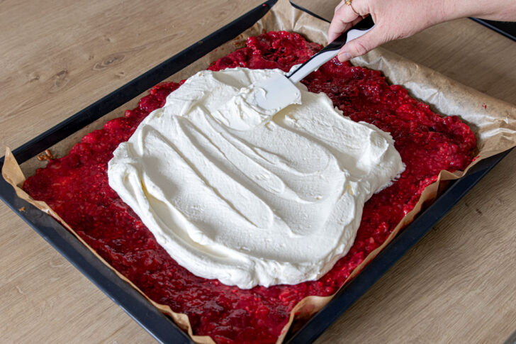 Sahne auf dem Butterkekskuchen verteilen