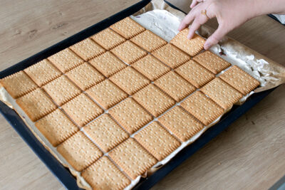 Butterkekse auf den Kuchen legen