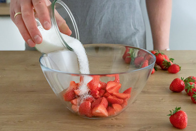 Zucker zu den Erdbeeren geben