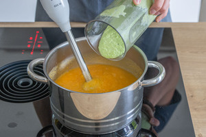 Pürierte Erbsen zur Gemüsesuppe geben