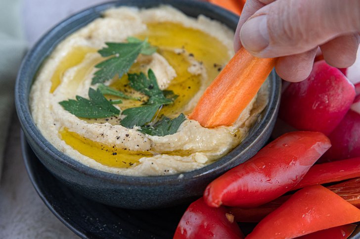 Karotte in Hummus dippen
