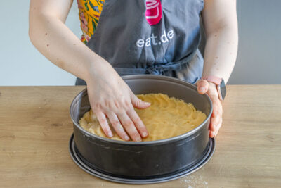 Mürbeteig für Omas Käsekuchen in Form drücken