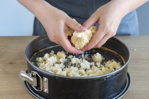 Streusel auf dem Mohnkuchen verteilen