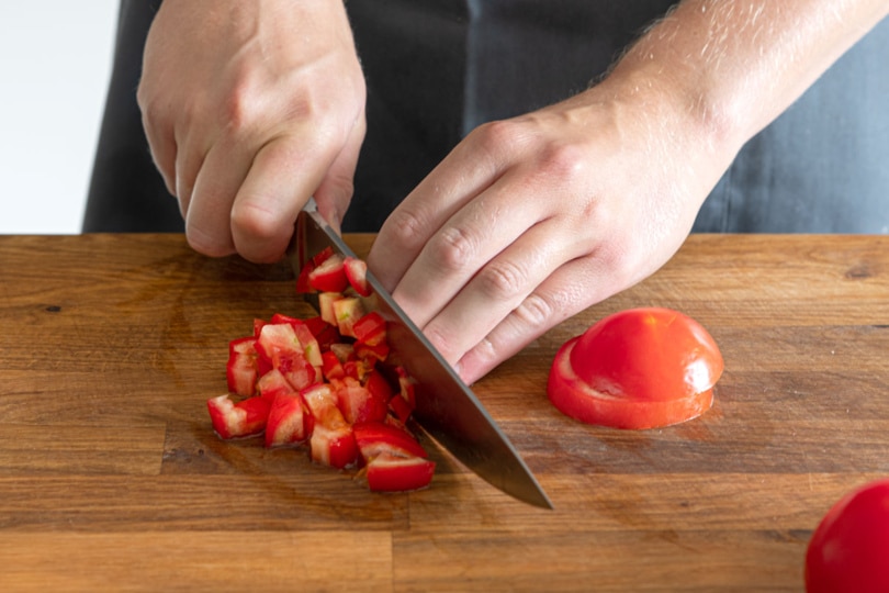 Tomaten in Stücke schneiden