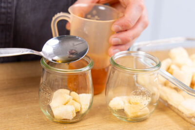 Löffelbiskuit im Glas mit Amaretto-Apfelsaft-Mischung beträufeln