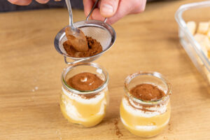 Apfeltiramisu im Glas mit Kakao bestäuben