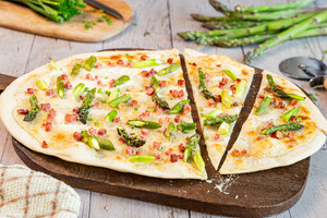 Flammkuchen mit Schinken und grünem Spargel geschnitten