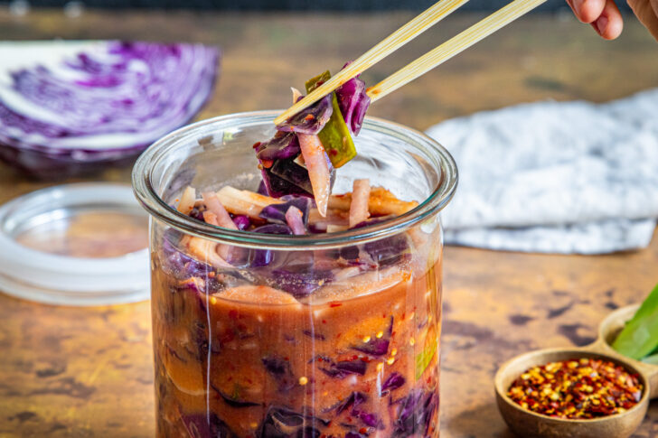 Rotkohl Kimchi mit Stäbchen herausnehmen