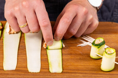 Füllung auf die Zucchinistreifen geben und zusammenrollen