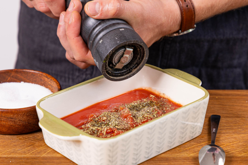Tomatensoße in der Auflaufform würzen
