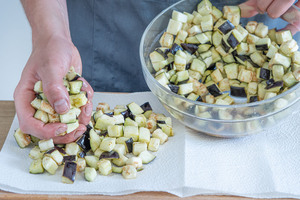 Gesalzene Aubergine mit einem Küchentuch abtupfen