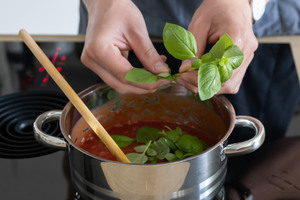 Basilikum zu Tomatensauce für Auberginenauflaufgeben