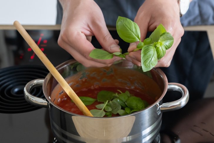 Basilikum zu Tomatensauce für Auberginenauflaufgeben