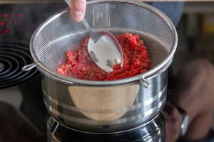 Johannisbeeren durch das Sieb drücken