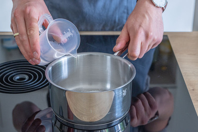 Für die Wassermelonensuppe Wasser zum Zucker geben