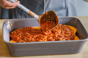Kürbis und Hackfleisch aufeinander schichten
