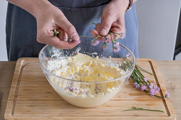 Schnittlauchblüten zu Butter geben