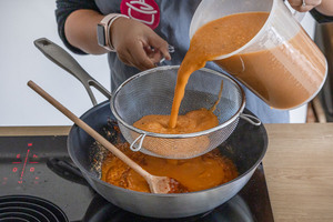 Sahi Paneer Soße in einen Sieb gießen
