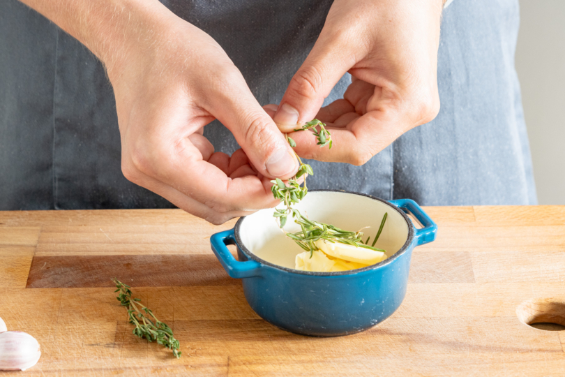 Kräuter zur Butter geben