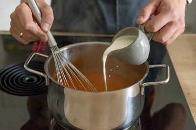 Sahne zur Tomatencremesuppe geben