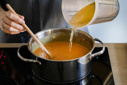 Gemüsebrühe zur Linsensuppe geben