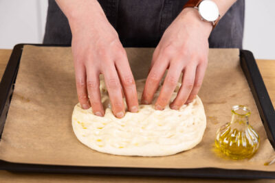 Teig formen und mit den Fingern Mulden formen